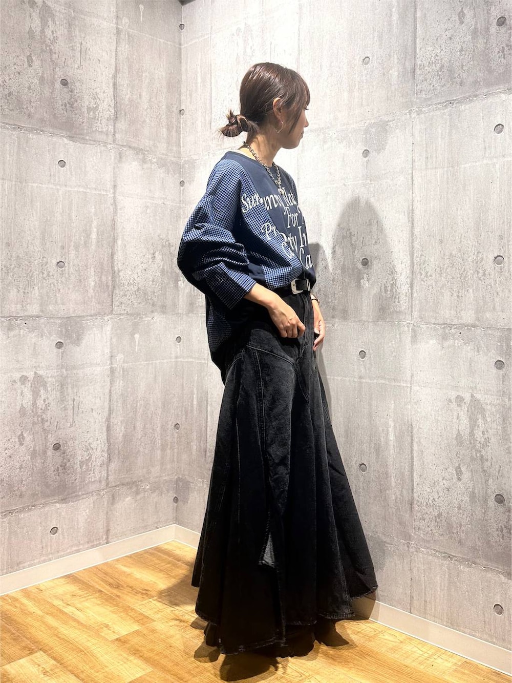 ブラック系のブーツ、ブラック系のデニムスカート、ブルー系のTシャツ/カットソーを着用したレディースの秋コーディネートの4枚目の写真