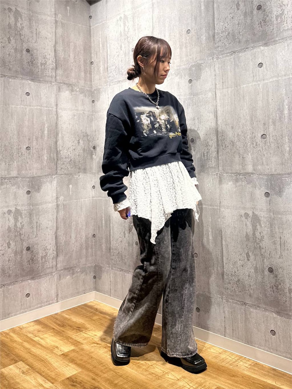 グレー系のスウェット、ブラック系のデニムパンツ、ホワイト系のチュニックを着用したレディースの秋コーディネートの4枚目の写真
