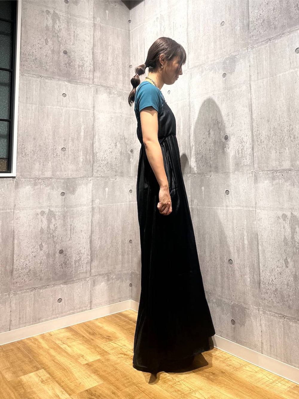 ブラック系のワンピース、ブラック系のサンダル、グリーン系のTシャツ/カットソーを着用したレディースの秋コーディネートの2枚目の写真