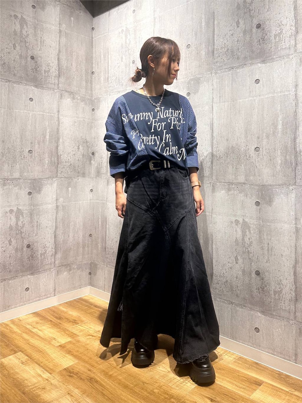 ブラック系のブーツ、ブラック系のデニムスカート、ブルー系のTシャツ/カットソーを着用したレディースの秋コーディネートの6枚目の写真