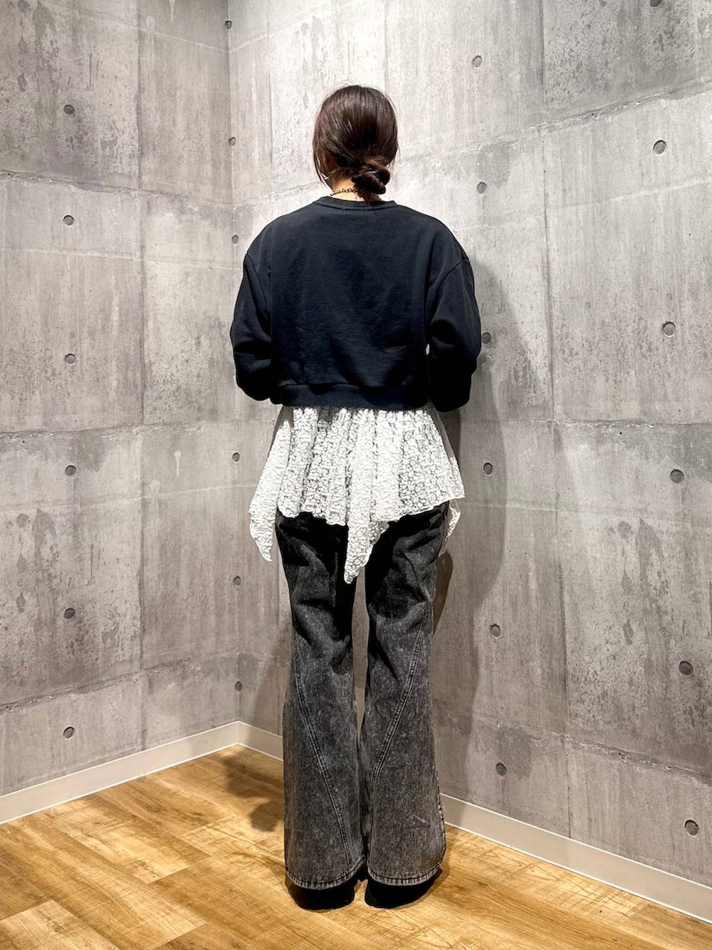 グレー系のスウェット、ブラック系のデニムパンツ、ホワイト系のチュニックを着用したレディースの秋コーディネートの3枚目の写真