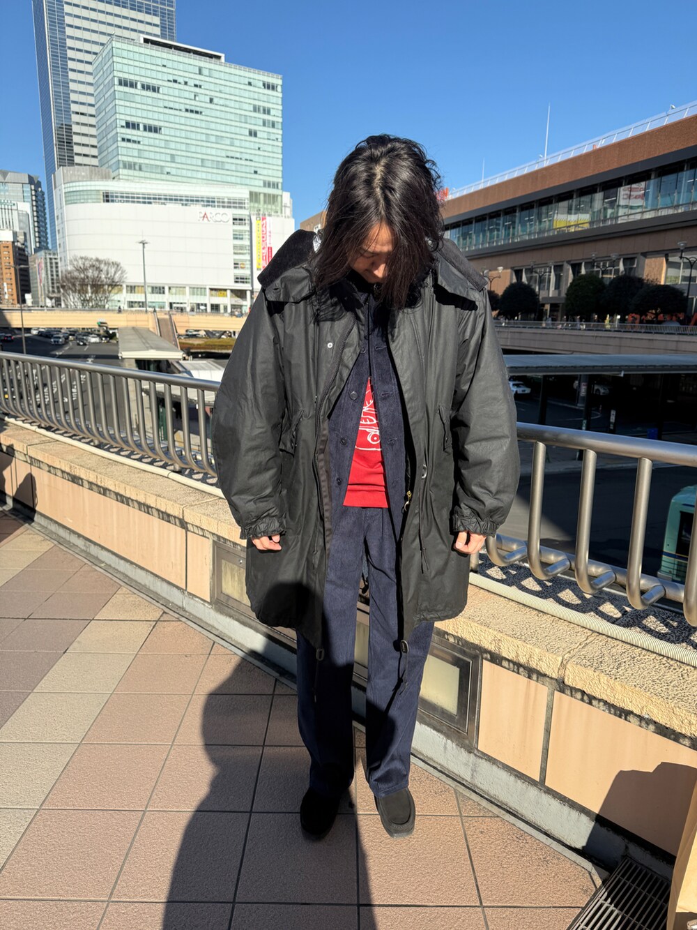 ブラック系のシューズ、ブルー系のパンツ、レッド系のスウェットを着用したメンズの冬コーディネートの2枚目の写真