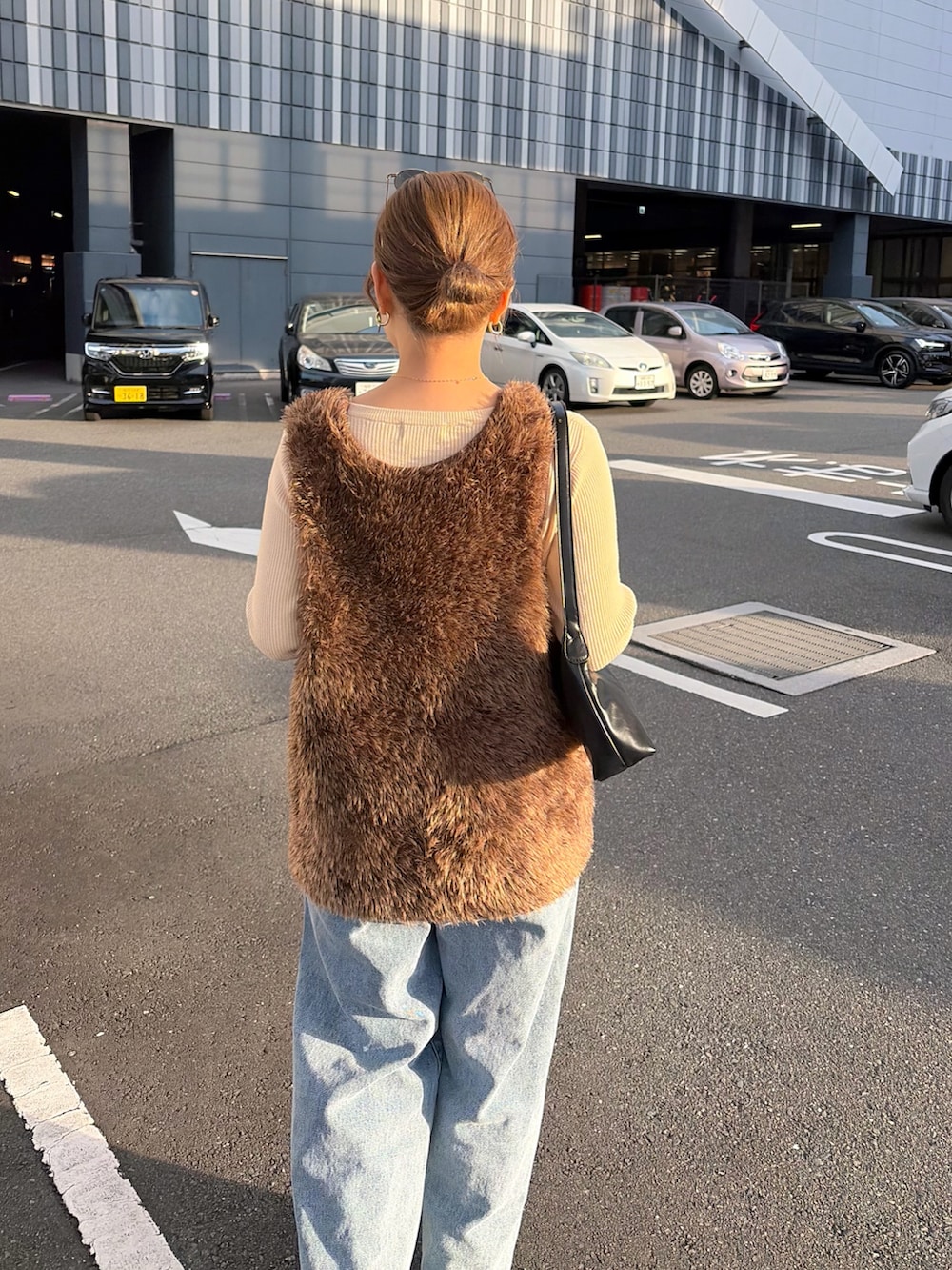 ホワイト系のニット/セーター、ブルー系のデニムパンツ、ブラウン系のニット/セーターを着用したレディースの冬コーディネートの5枚目の写真