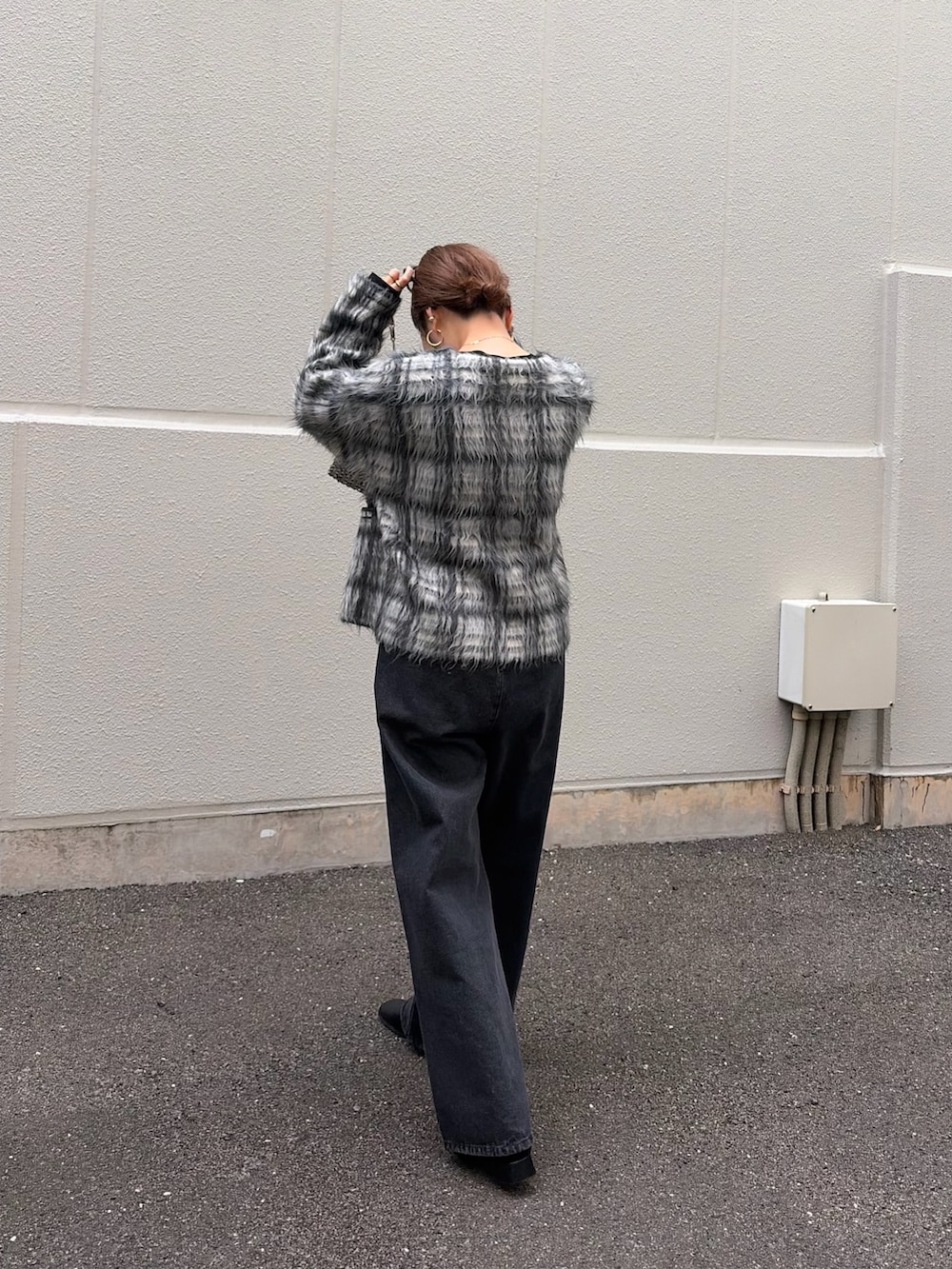 ブラック系のTシャツ/カットソー、ホワイト系のニット/セーター、ブラック系のデニムパンツを着用したレディースの秋コーディネートの2枚目の写真