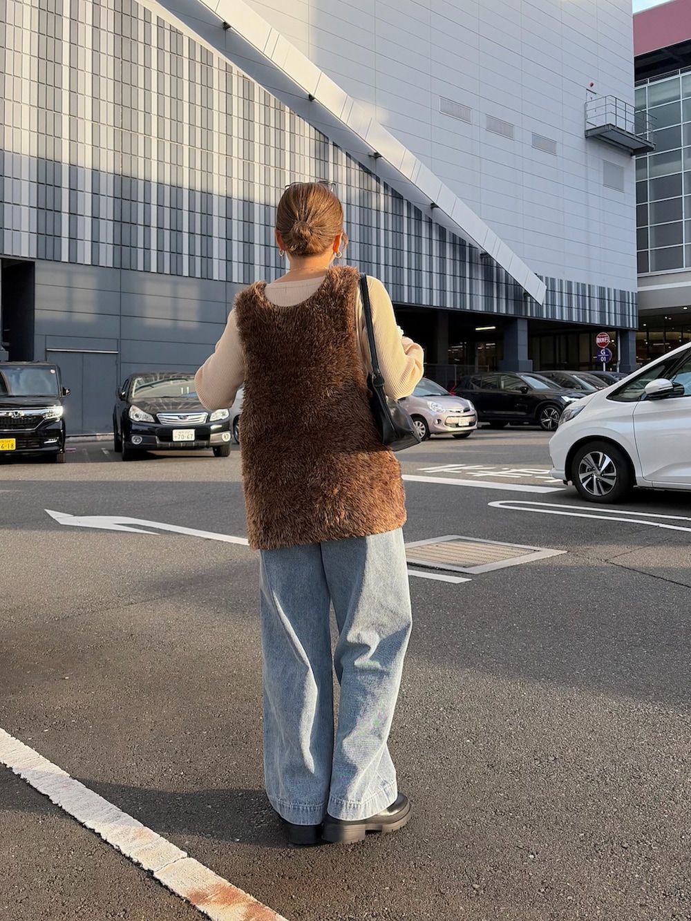 ホワイト系のニット/セーター、ブルー系のデニムパンツ、ブラウン系のニット/セーターを着用したレディースの冬コーディネートの3枚目の写真