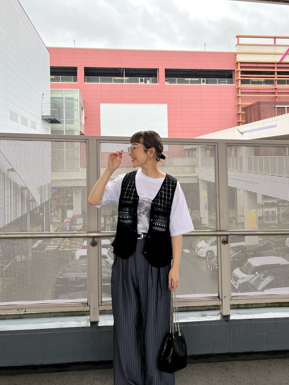 ブラック系のベスト、ホワイト系のTシャツ/カットソー、ホワイト系のスニーカーを着用したレディースの春コーディネートの2枚目の写真