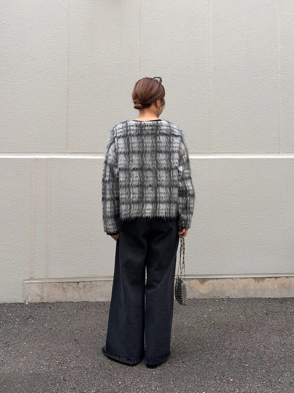 ブラック系のTシャツ/カットソー、ホワイト系のニット/セーター、ブラック系のデニムパンツを着用したレディースの秋コーディネートの3枚目の写真