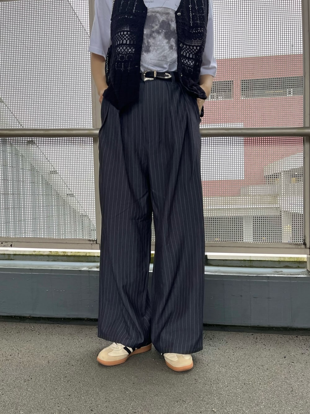 ブラック系のベスト、ホワイト系のTシャツ/カットソー、ホワイト系のスニーカーを着用したレディースの春コーディネートの5枚目の写真