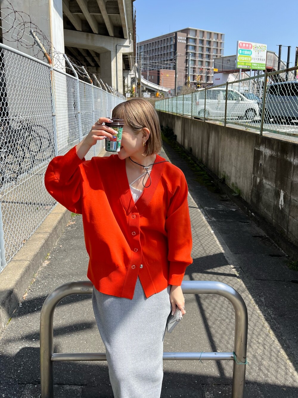 オレンジ系のカーディガン/ボレロ、ホワイト系のTシャツ/カットソー、グレー系のスカートを着用したレディースの春コーディネートの5枚目の写真