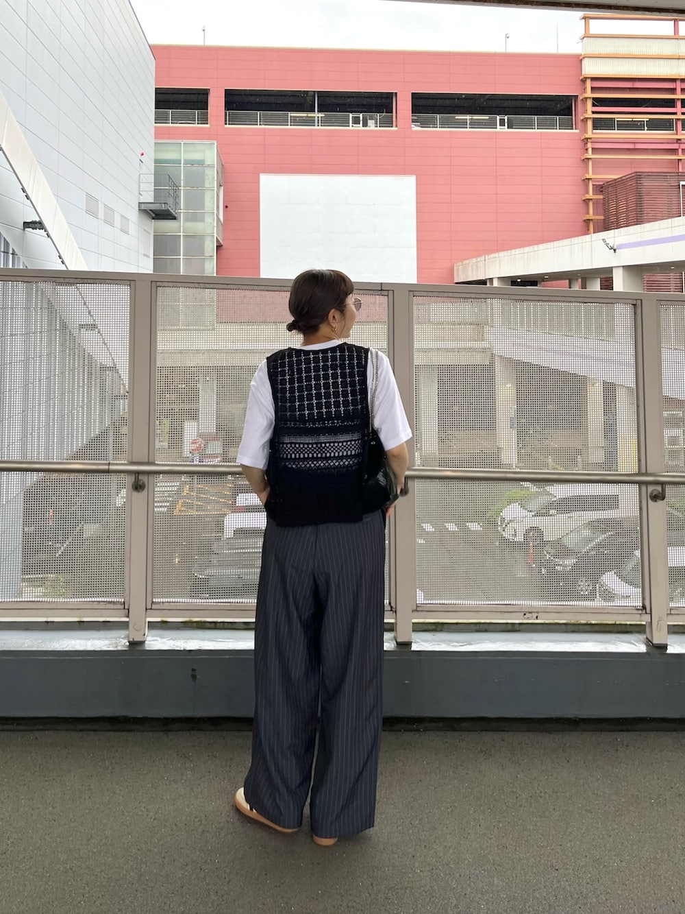 ブラック系のベスト、ホワイト系のTシャツ/カットソー、ホワイト系のスニーカーを着用したレディースの春コーディネートの3枚目の写真