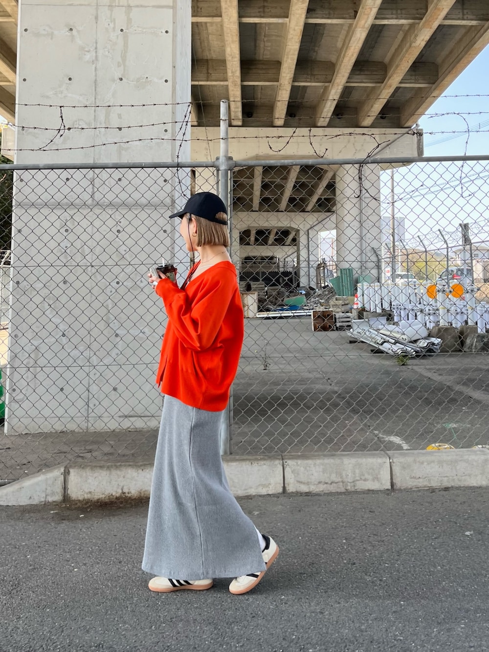 オレンジ系のカーディガン/ボレロ、ホワイト系のTシャツ/カットソー、グレー系のスカートを着用したレディースの春コーディネートの3枚目の写真