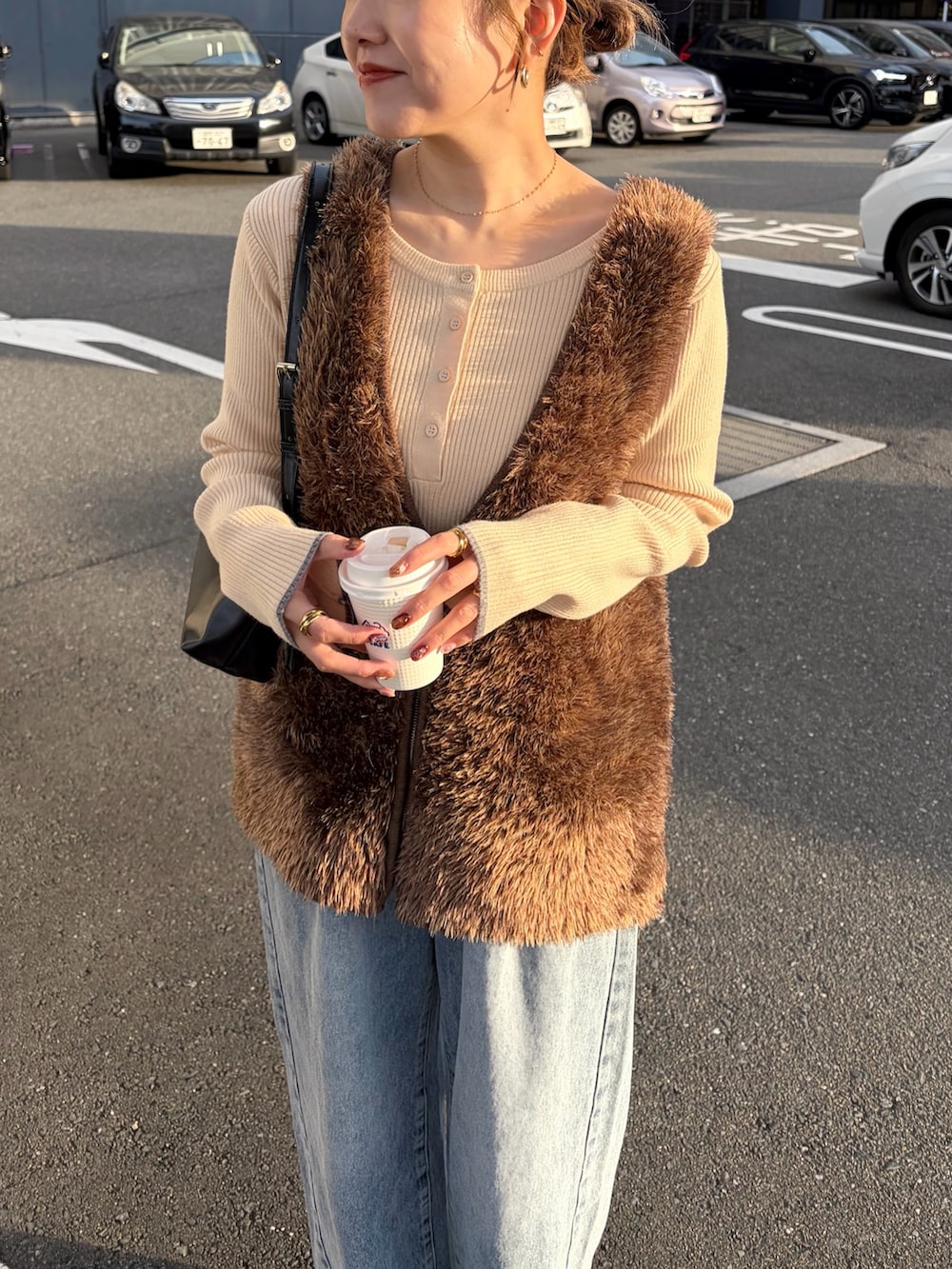 ホワイト系のニット/セーター、ブルー系のデニムパンツ、ブラウン系のニット/セーターを着用したレディースの冬コーディネートの4枚目の写真