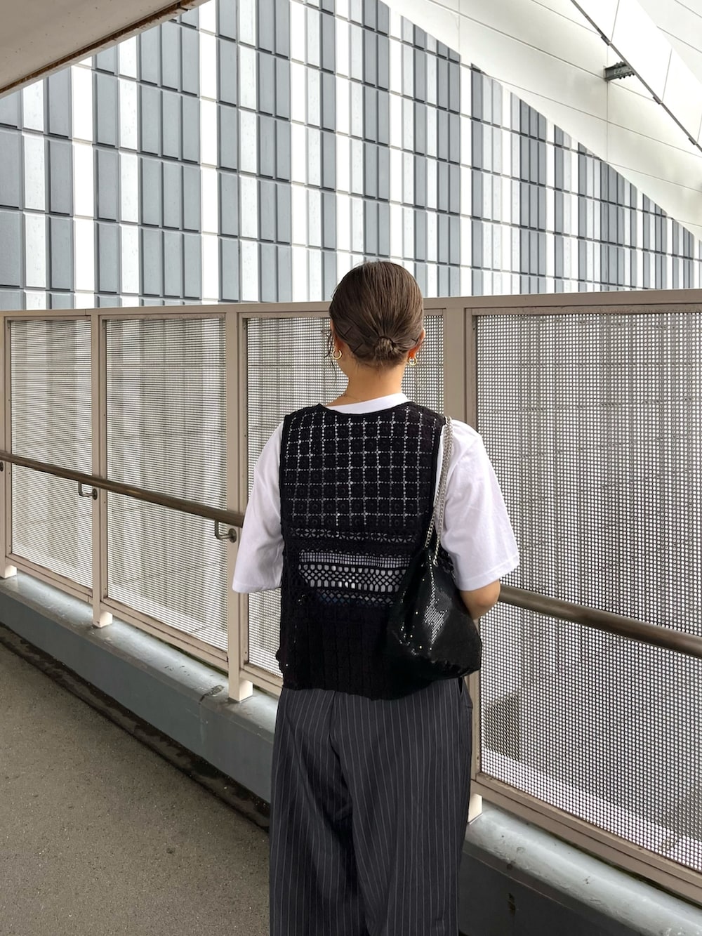 ブラック系のベスト、ホワイト系のTシャツ/カットソー、ホワイト系のスニーカーを着用したレディースの春コーディネートの4枚目の写真