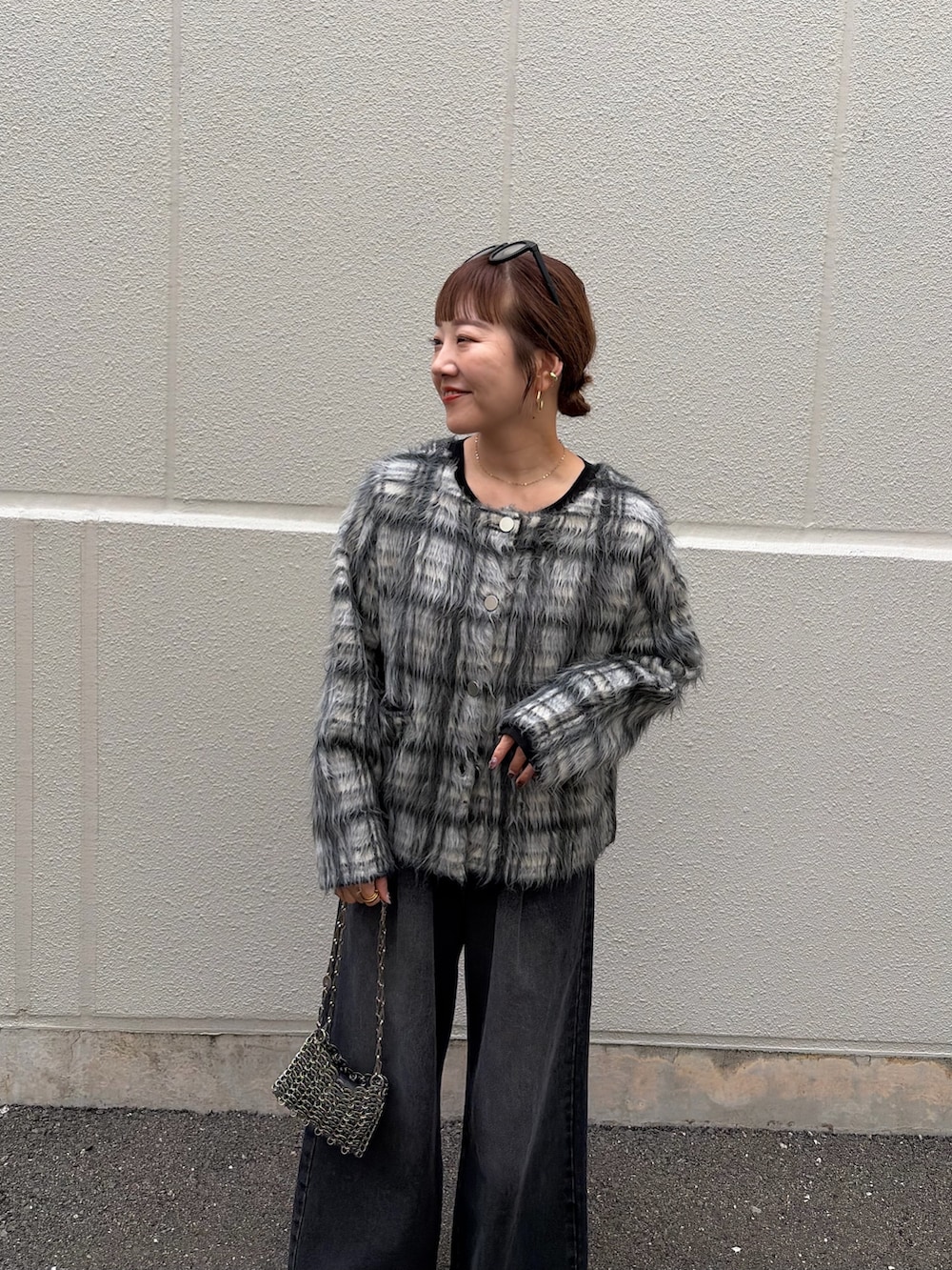 ブラック系のTシャツ/カットソー、ホワイト系のニット/セーター、ブラック系のデニムパンツを着用したレディースの秋コーディネートの4枚目の写真