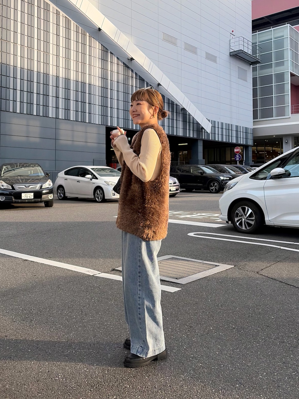 ホワイト系のニット/セーター、ブルー系のデニムパンツ、ブラウン系のニット/セーターを着用したレディースの冬コーディネートの2枚目の写真