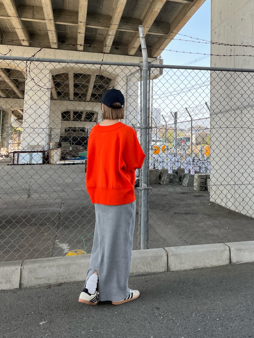 オレンジ系のカーディガン/ボレロ、ホワイト系のTシャツ/カットソー、グレー系のスカートを着用したレディースの春コーディネートの4枚目の写真
