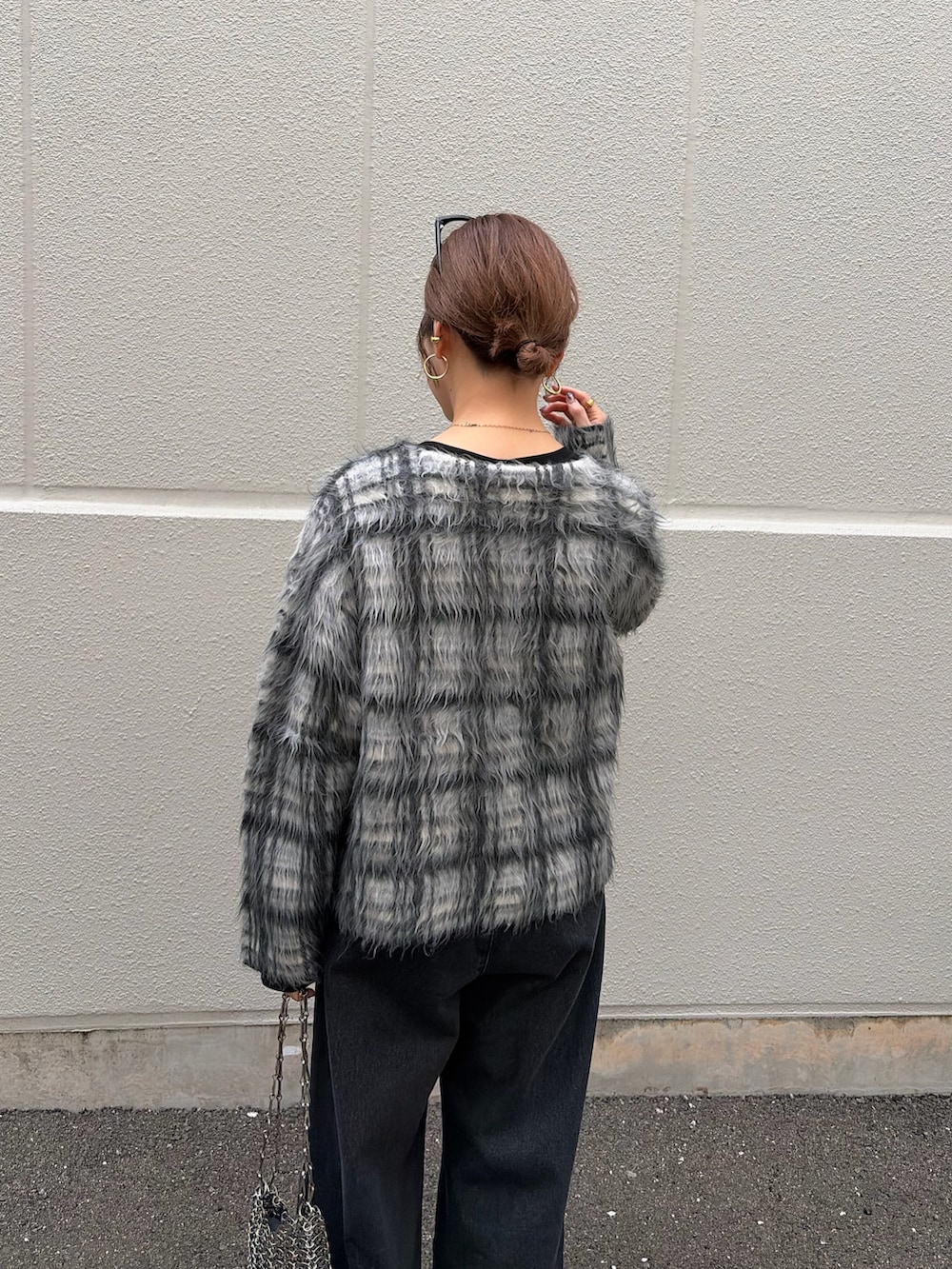 ブラック系のTシャツ/カットソー、ホワイト系のニット/セーター、ブラック系のデニムパンツを着用したレディースの秋コーディネートの6枚目の写真