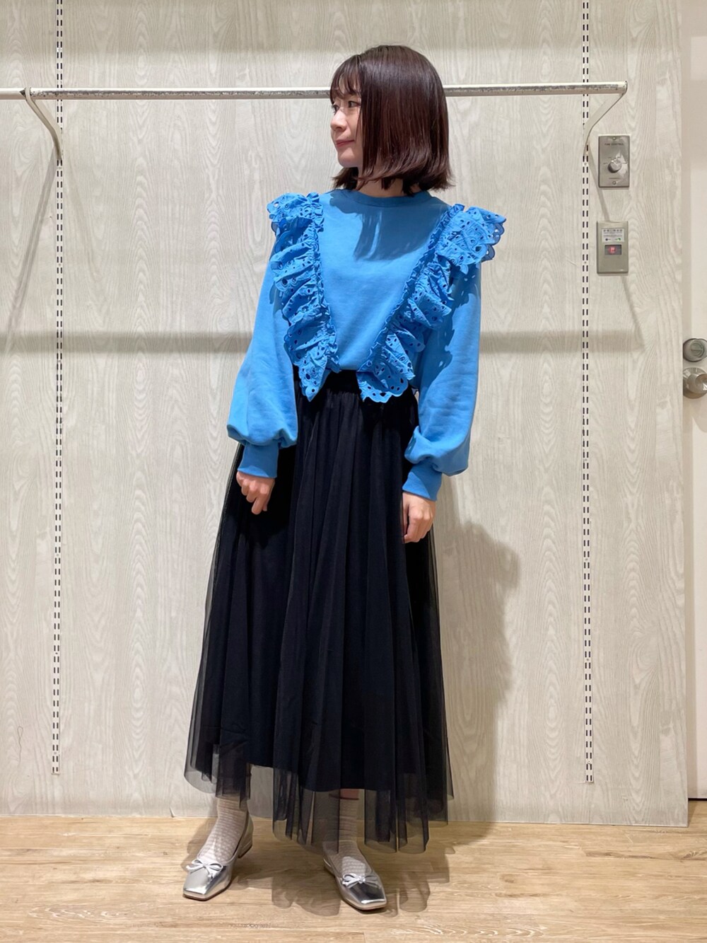 ブラック系のスカート、ブルー系のTシャツ/カットソー、シルバー系のシューズを着用したレディースの春コーディネートの2枚目の写真