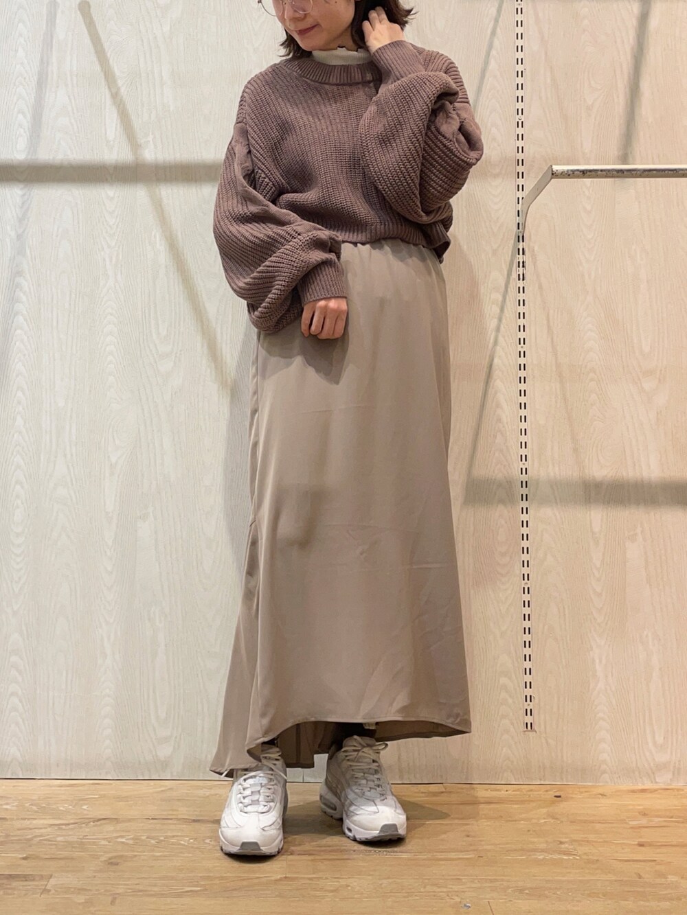 ベージュ系のスカート、ブラウン系のカーディガン/ボレロ、ホワイト系のTシャツ/カットソーを着用したレディースの冬コーディネートの2枚目の写真