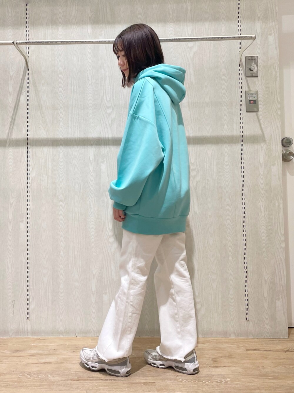 ホワイト系のデニムパンツ、グリーン系のスウェットを着用したレディースの春コーディネートの2枚目の写真