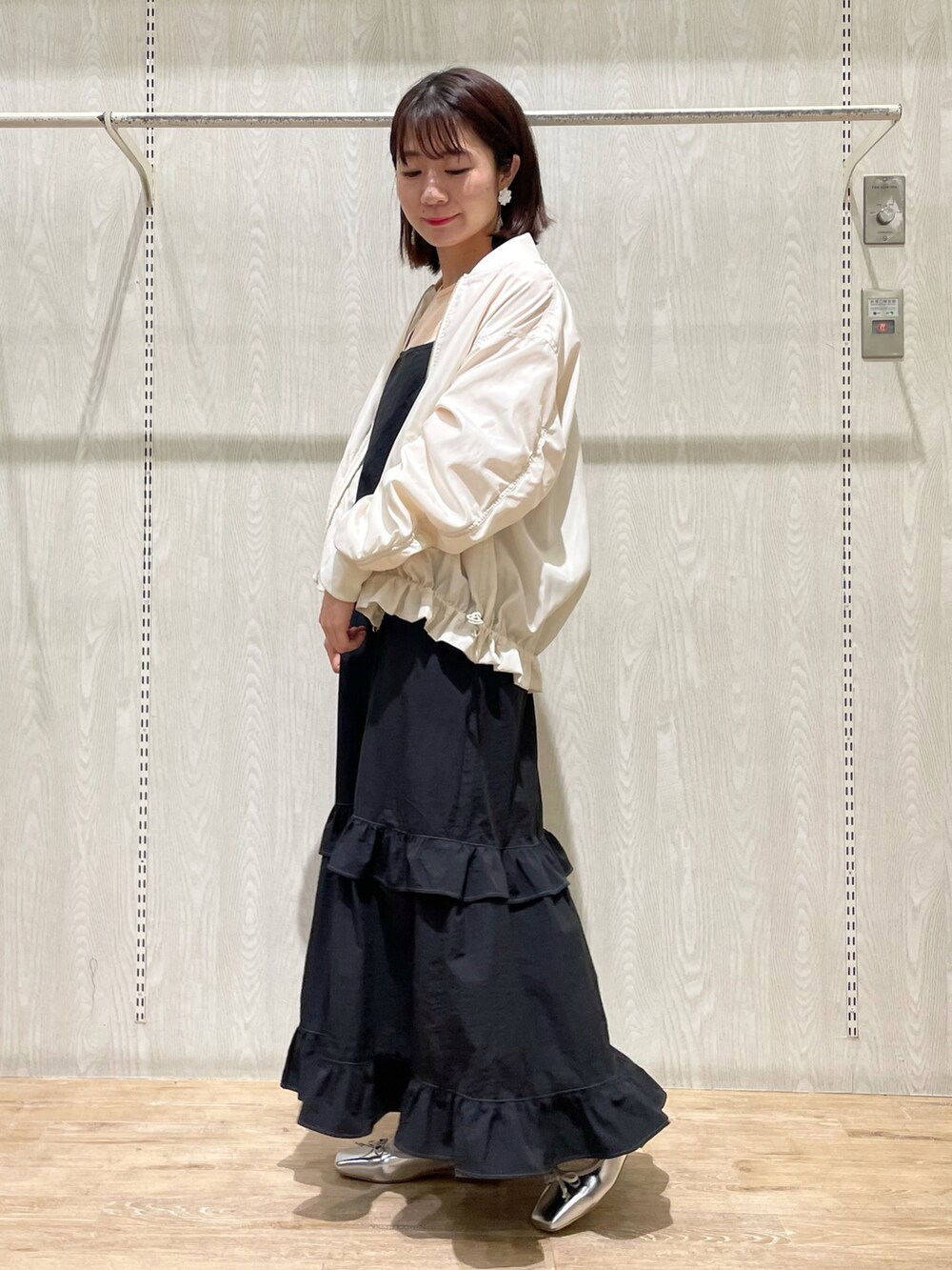 ブラック系のワンピース、ホワイト系のMA-1、シルバー系のシューズを着用したレディースの春コーディネートの2枚目の写真