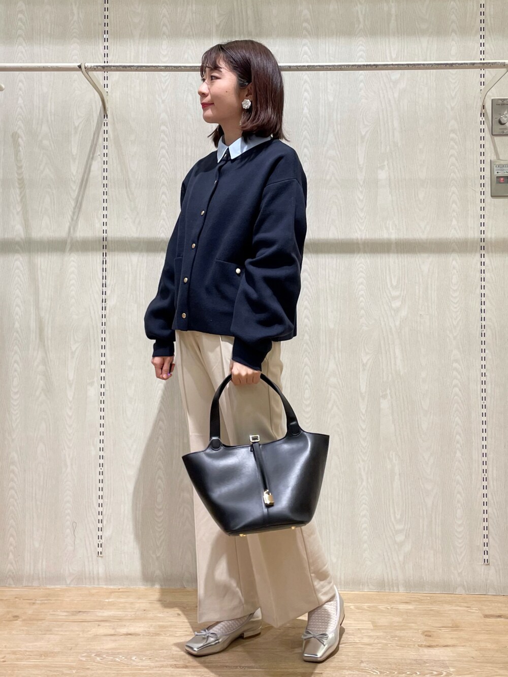ブラック系のエコバッグ/サブバッグ、ブルー系のカーディガン/ボレロ、ベージュ系のその他パンツを着用したレディースの春コーディネートの2枚目の写真