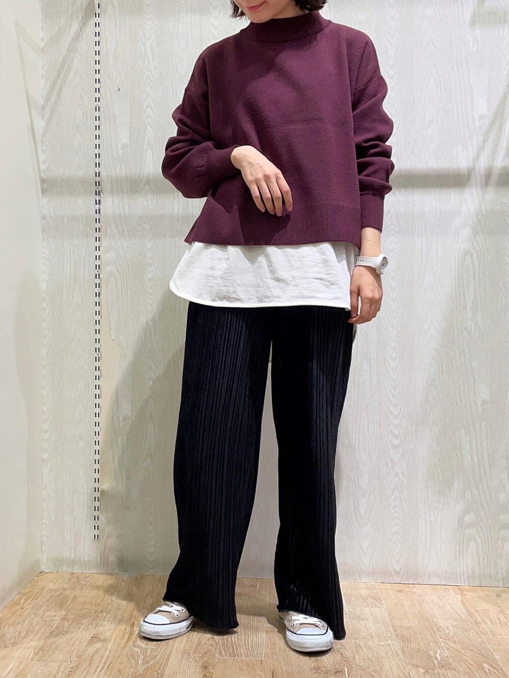 レッド系のニット/セーター、ブラック系のその他パンツ、ホワイト系のTシャツ/カットソーを着用したレディースの冬コーディネートの2枚目の写真