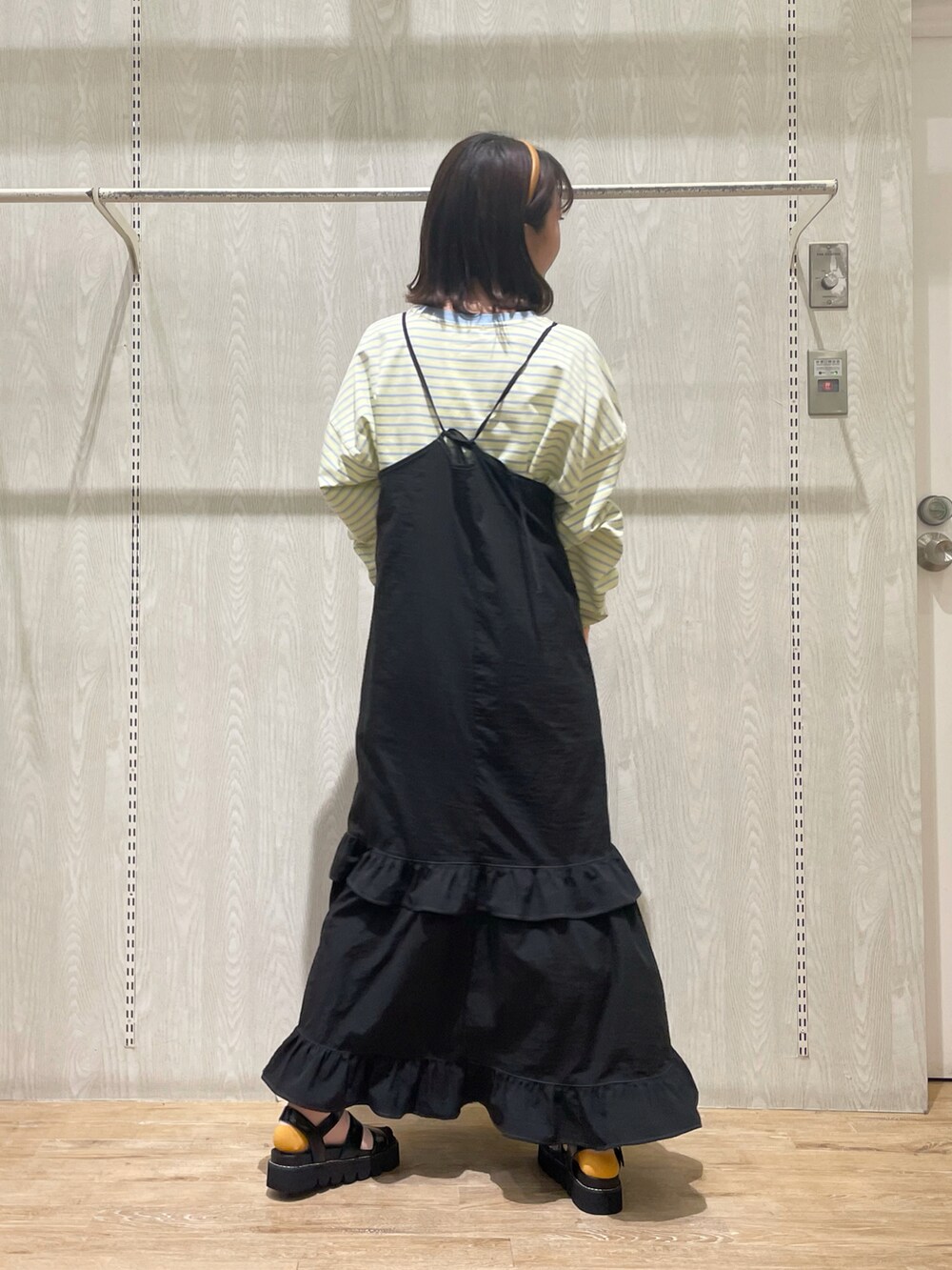 ブラック系のシューズ、ブラック系のワンピース、イエロー系のTシャツ/カットソーを着用したレディースの春コーディネートの4枚目の写真