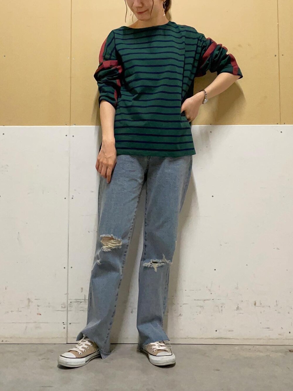 ブルー系のデニムパンツ、グリーン系のTシャツ/カットソーを着用したレディースの秋コーディネートの3枚目の写真