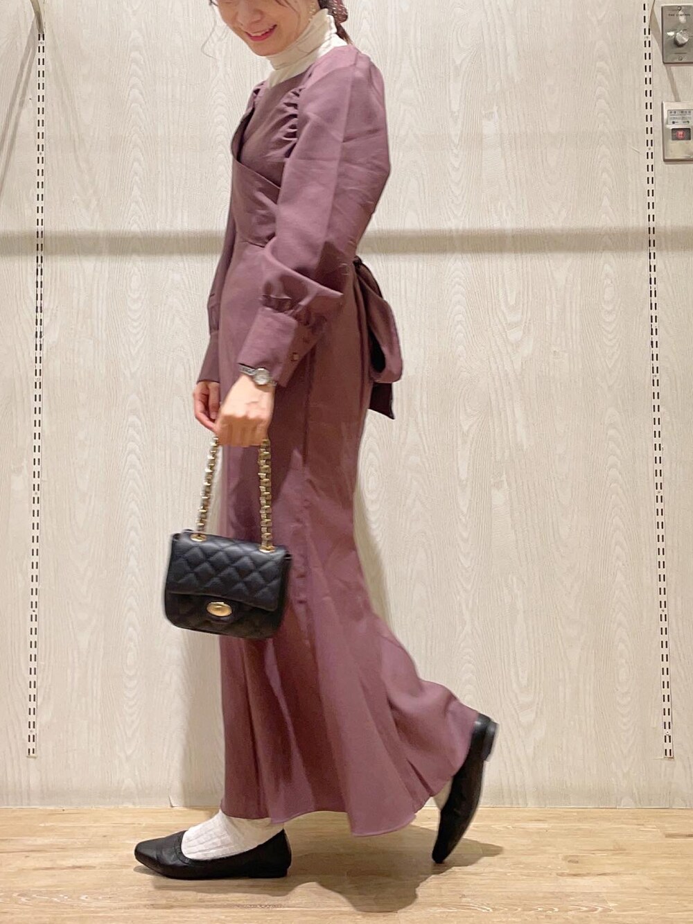 ブラック系のショルダーバッグ、ピンク系のワンピース、ホワイト系のTシャツ/カットソーを着用したレディースの秋コーディネートの2枚目の写真