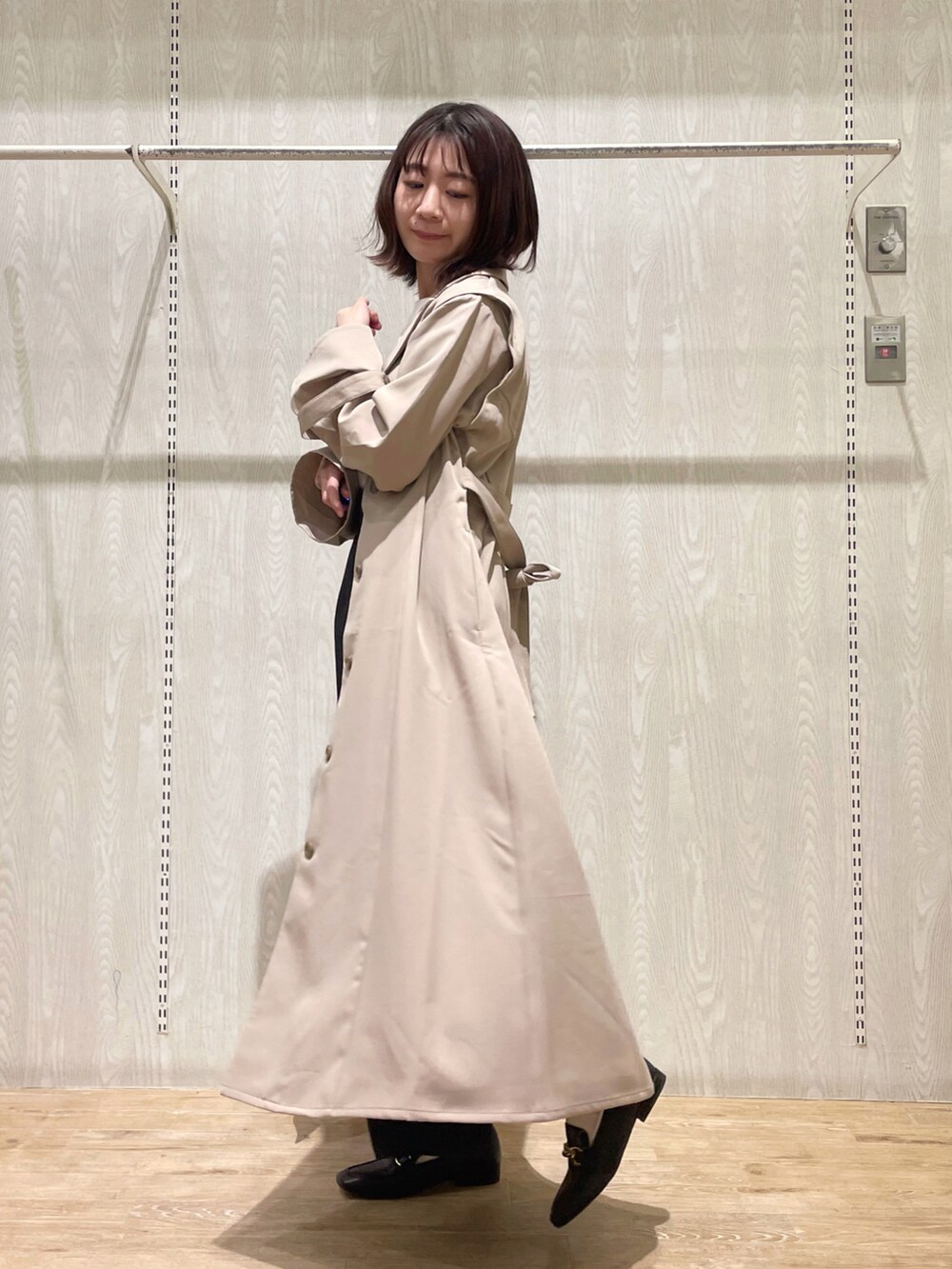 ブラック系のシャツ/ブラウス、ブラック系のスカート、ベージュ系のトレンチコートを着用したレディースの冬コーディネートの3枚目の写真