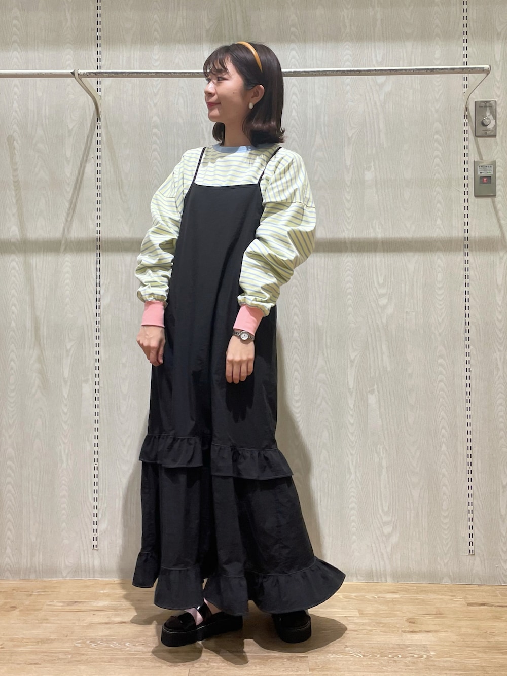 ブラック系のシューズ、ブラック系のワンピース、イエロー系のTシャツ/カットソーを着用したレディースの春コーディネートの3枚目の写真