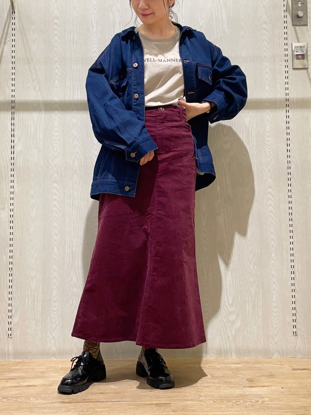 ブルー系のデニムジャケット、レッド系のスカート、ベージュ系のTシャツ/カットソーを着用したレディースの秋コーディネートの2枚目の写真