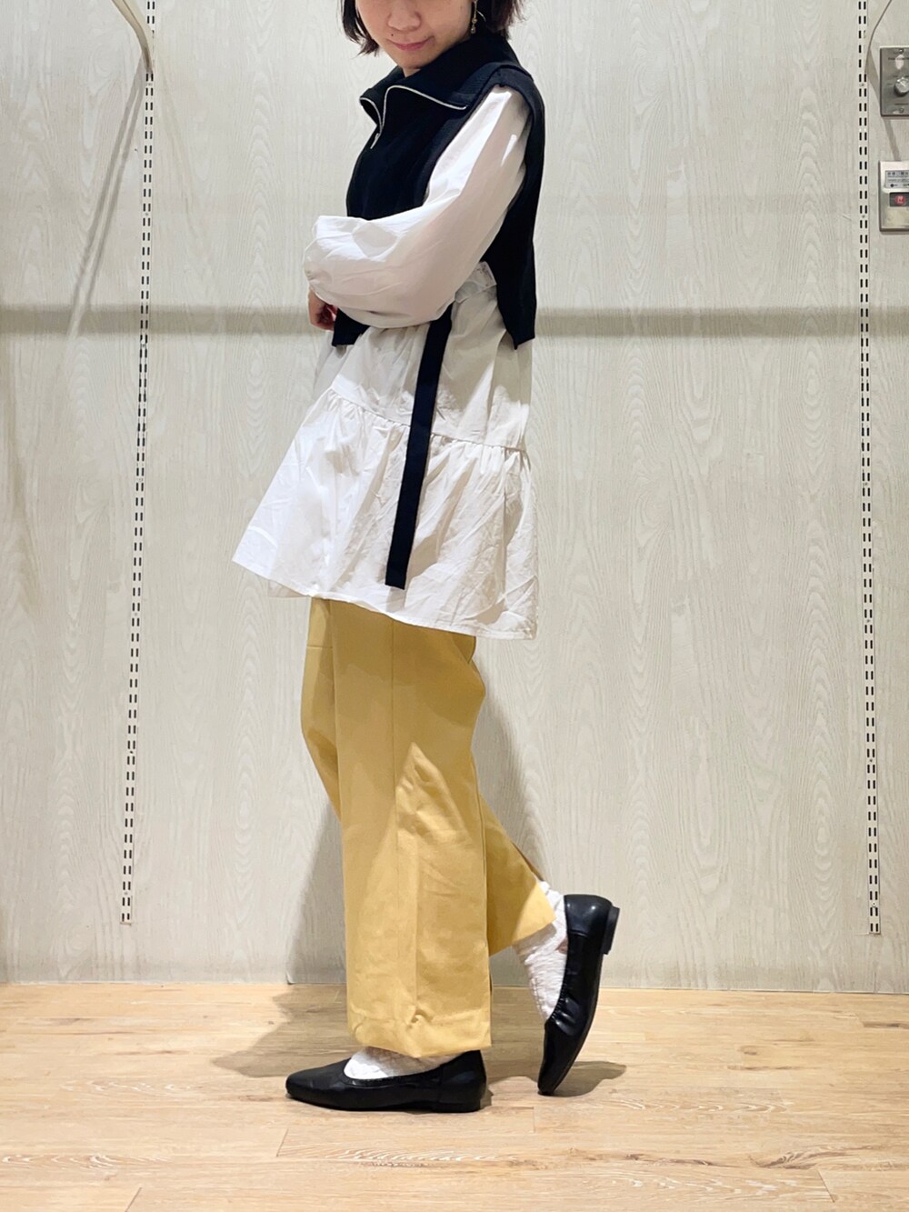 イエロー系のその他パンツ、ブラック系のベスト、ホワイト系のTシャツ/カットソーを着用したレディースの春コーディネートの2枚目の写真