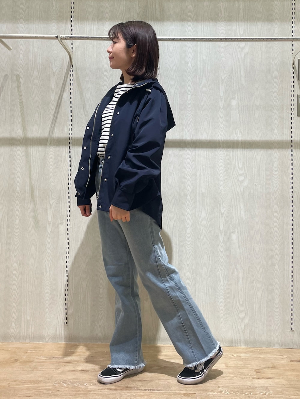 ブルー系のデニムパンツ、ブラック系のTシャツ/カットソー、ブルー系のマウンテンパーカーを着用したレディースの春コーディネートの2枚目の写真