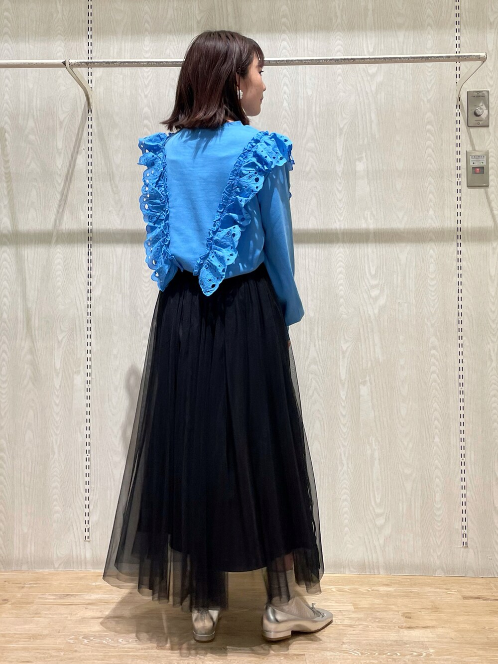 ブラック系のスカート、ブルー系のTシャツ/カットソー、シルバー系のシューズを着用したレディースの春コーディネートの3枚目の写真