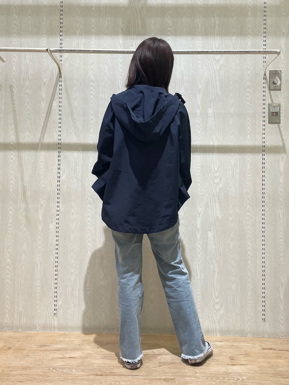 ブルー系のデニムパンツ、ブラック系のTシャツ/カットソー、ブルー系のマウンテンパーカーを着用したレディースの春コーディネートの3枚目の写真