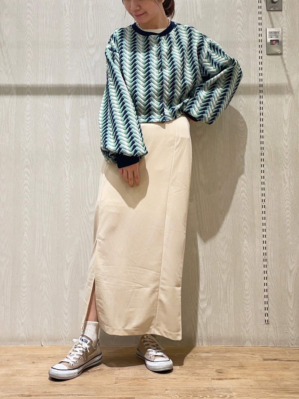 ホワイト系のスカート、グリーン系のカーディガン/ボレロ、ホワイト系のTシャツ/カットソーを着用したレディースの秋コーディネートの2枚目の写真