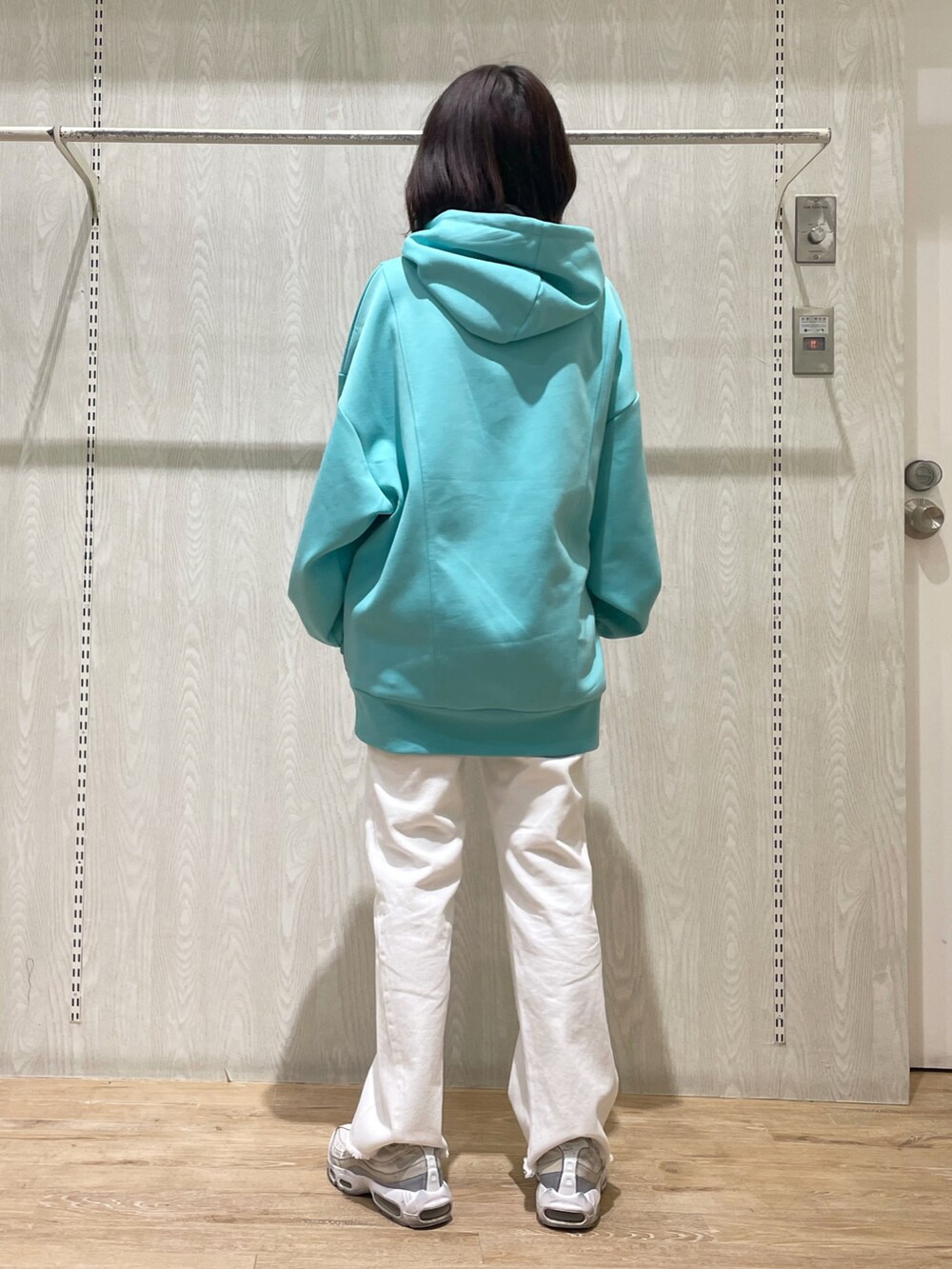 ホワイト系のデニムパンツ、グリーン系のスウェットを着用したレディースの春コーディネートの3枚目の写真