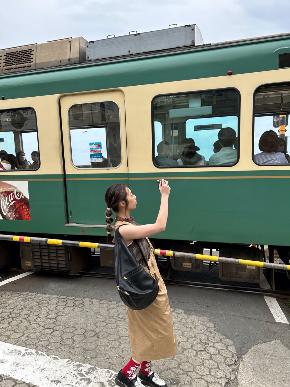 ベージュ系のワンピース/ドレス、グリーン系のベスト、ブラック系のローファーを着用したレディースの夏コーディネートの2枚目の写真