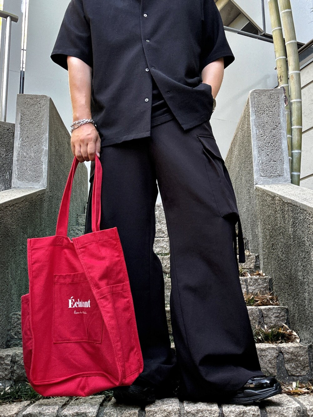 ブラック系のカーゴパンツ、レッド系のトートバッグ、ブラック系のシャツ/ブラウスを着用したメンズの秋コーディネートの5枚目の写真