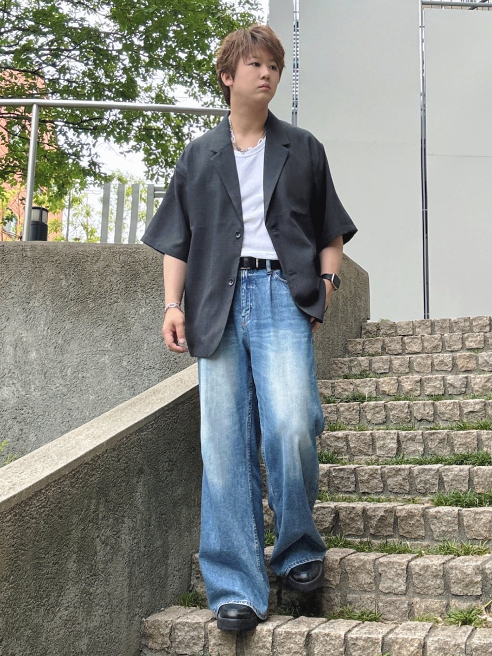 ブルー系のデニムパンツ、ブラック系のドレスシューズ、ブラック系のシャツ/ブラウスを着用したメンズの夏コーディネートの3枚目の写真