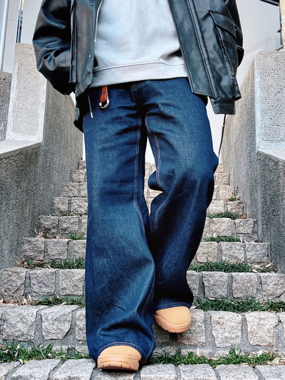 ブルー系のデニムパンツ、ブラック系のブルゾン、グレー系のスウェットを着用したメンズの冬コーディネートの5枚目の写真