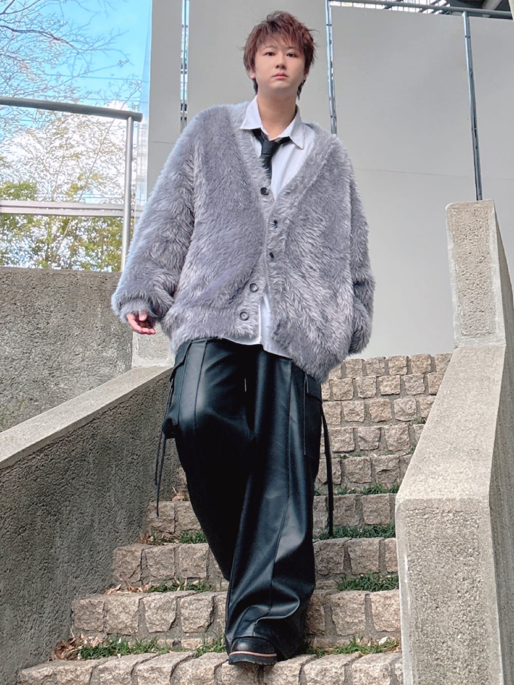 ブラック系のカーゴパンツ、グレー系のカーディガン/ボレロ、ブラック系のネクタイを着用したメンズの冬コーディネートの3枚目の写真