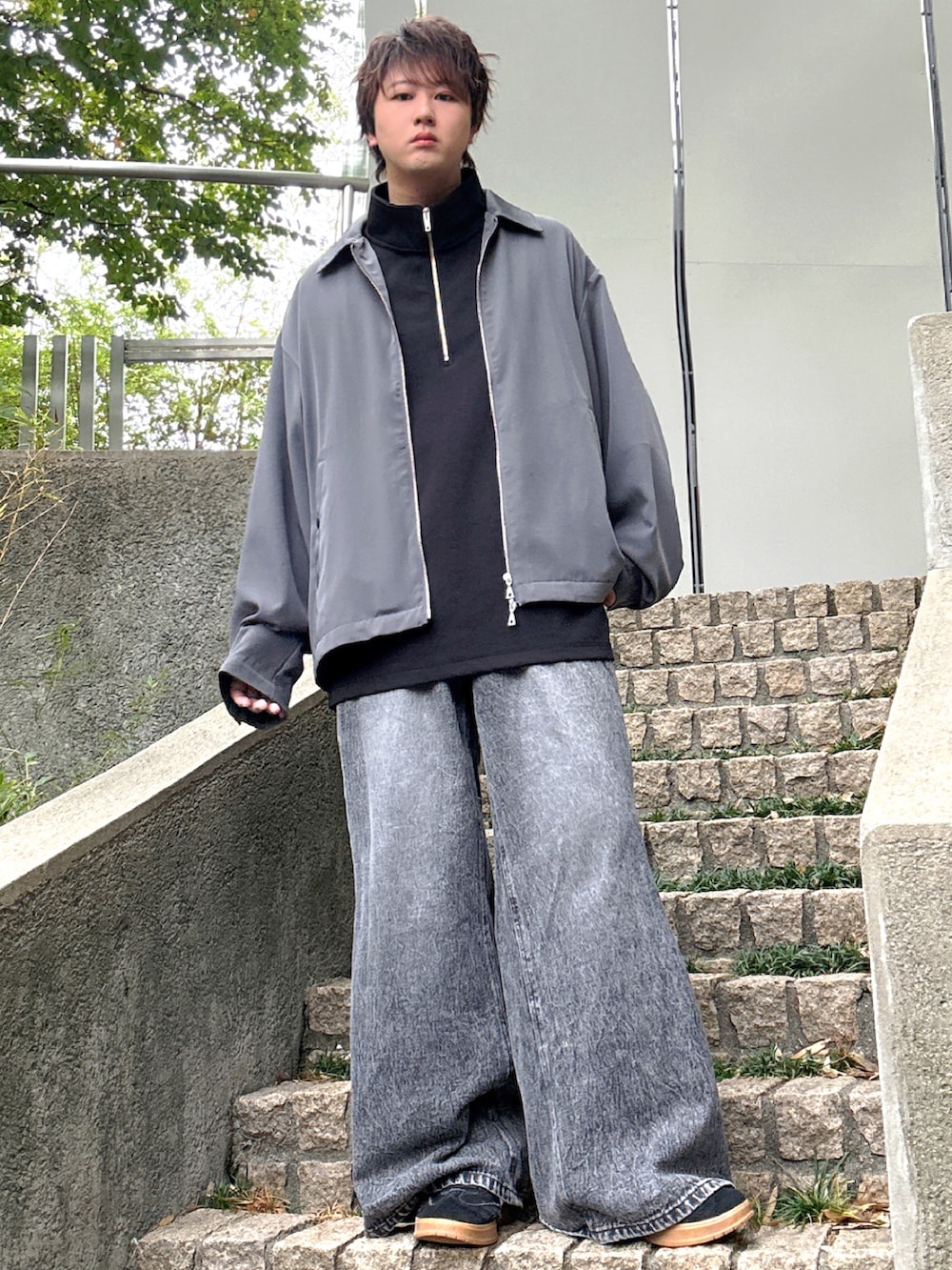 ブラック系のデニムパンツ、ブラック系のTシャツ/カットソー、グレー系のブルゾンを着用したメンズの秋コーディネートの4枚目の写真