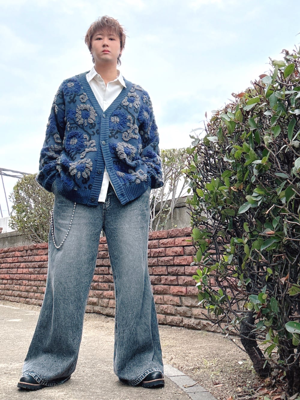 ブラック系のデニムパンツ、ブルー系のカーディガン/ボレロ、ホワイト系のシャツ/ブラウスを着用したメンズの冬コーディネートの2枚目の写真