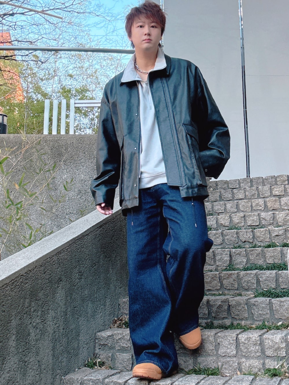 ブルー系のデニムパンツ、ブラック系のブルゾン、グレー系のスウェットを着用したメンズの冬コーディネートの3枚目の写真