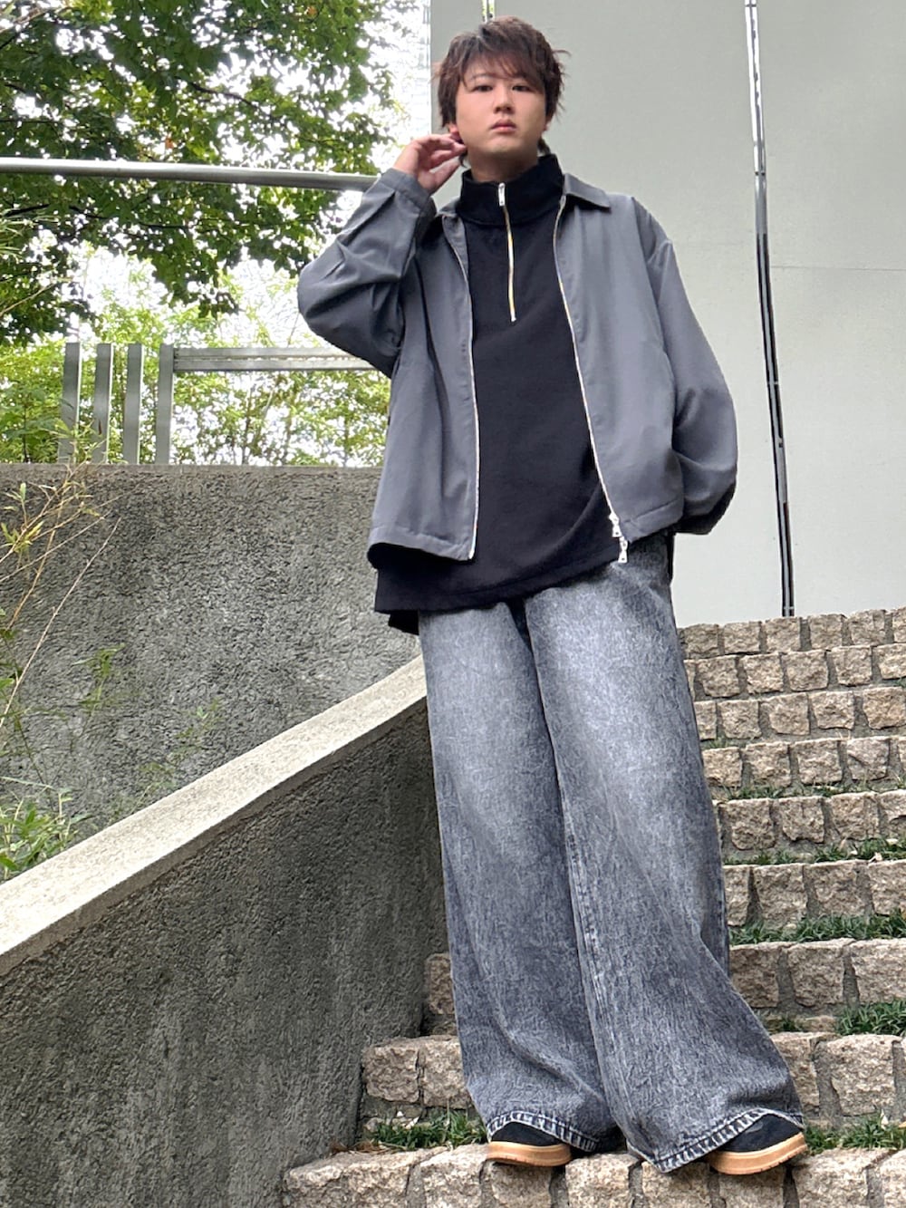 ブラック系のデニムパンツ、ブラック系のTシャツ/カットソー、グレー系のブルゾンを着用したメンズの秋コーディネートの3枚目の写真