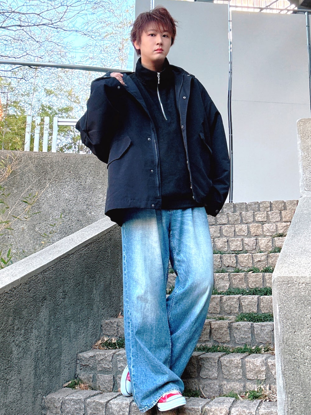 ブルー系のデニムパンツ、レッド系のスニーカー、ブラック系のブルゾンを着用したメンズの冬コーディネートの2枚目の写真