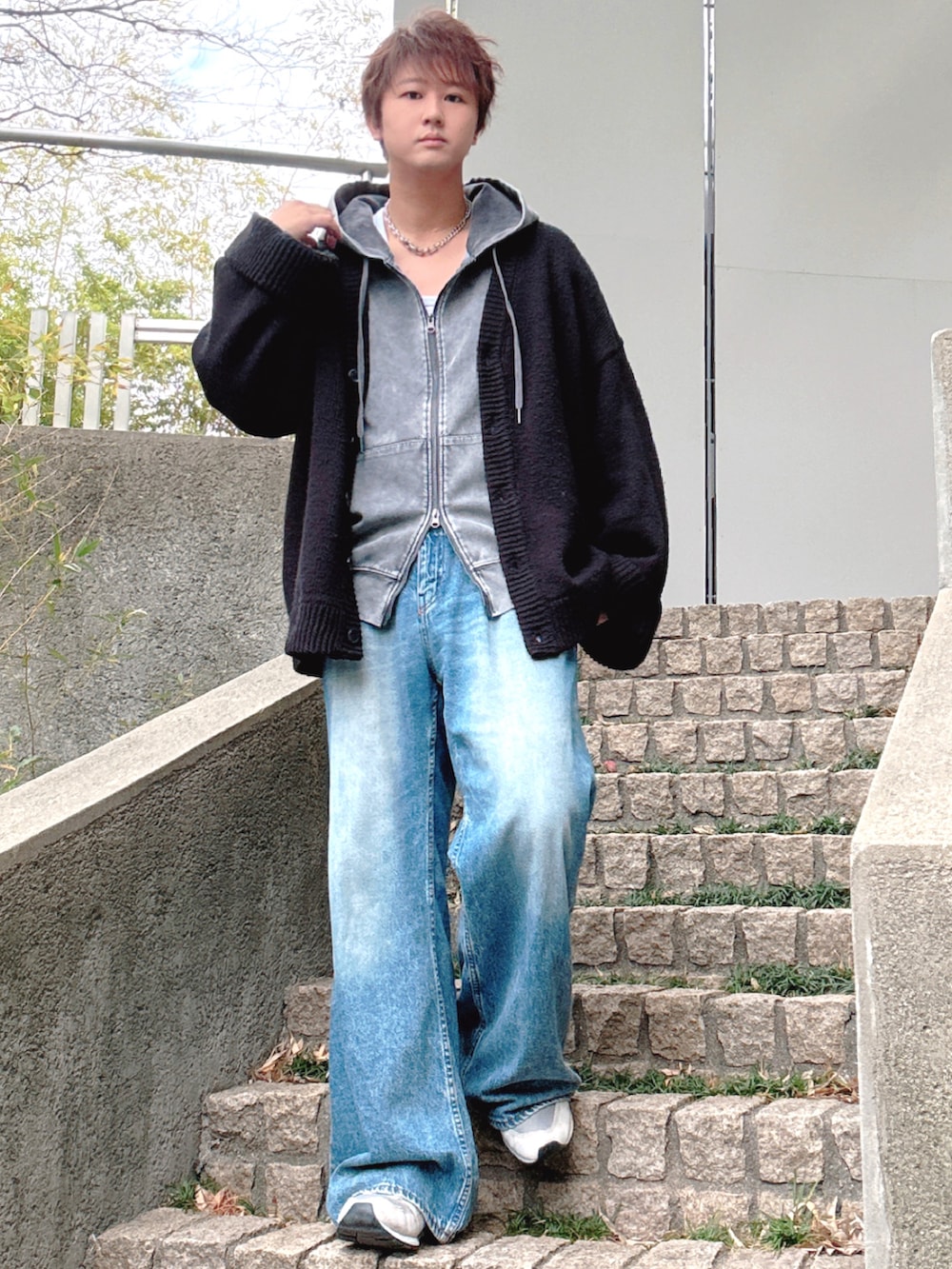 ブルー系のデニムパンツ、グレー系のスニーカー、ブラック系のカーディガン/ボレロを着用したメンズの冬コーディネートの3枚目の写真